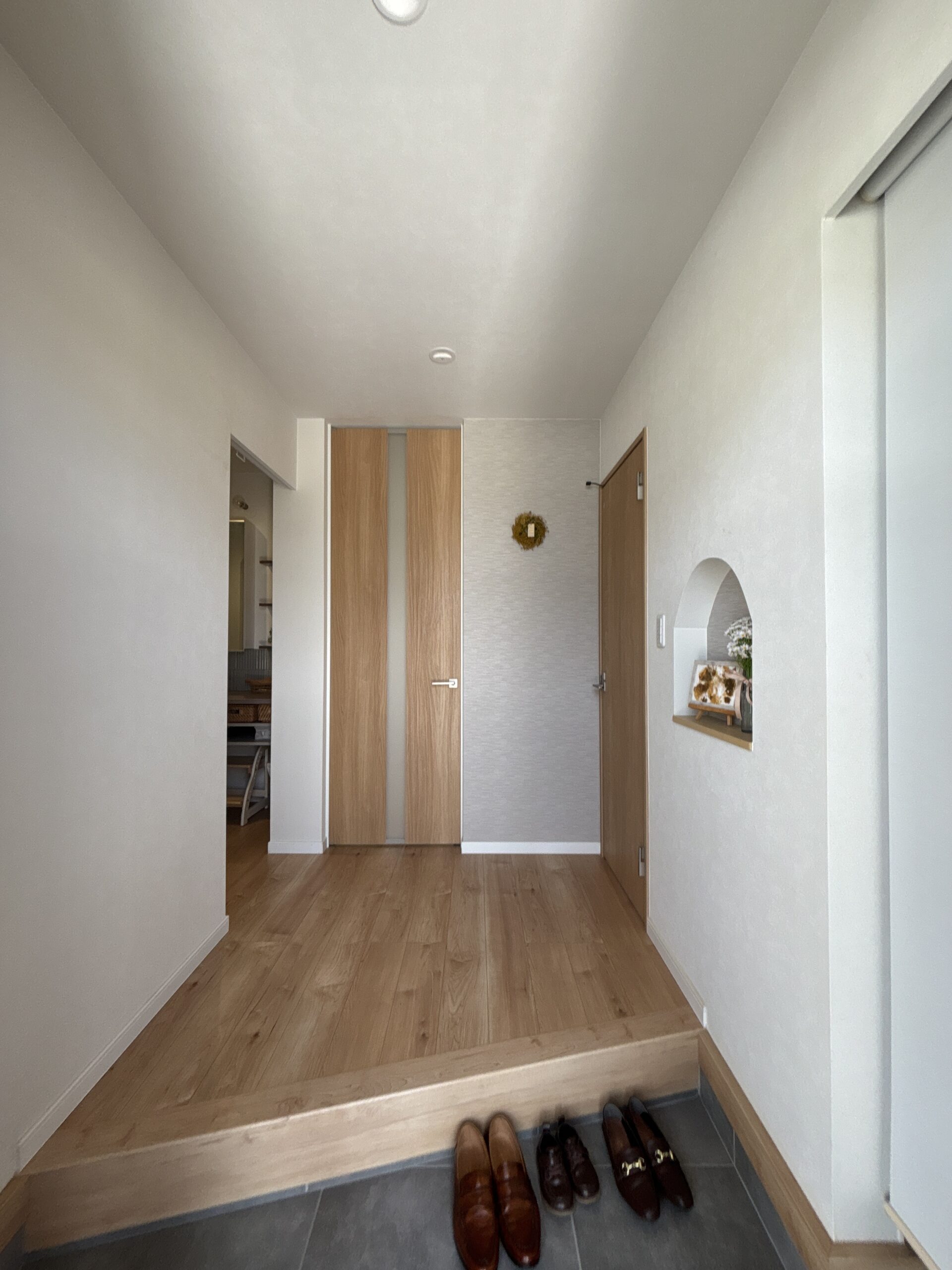 木の床とアーチニッチのある玄関ホール
