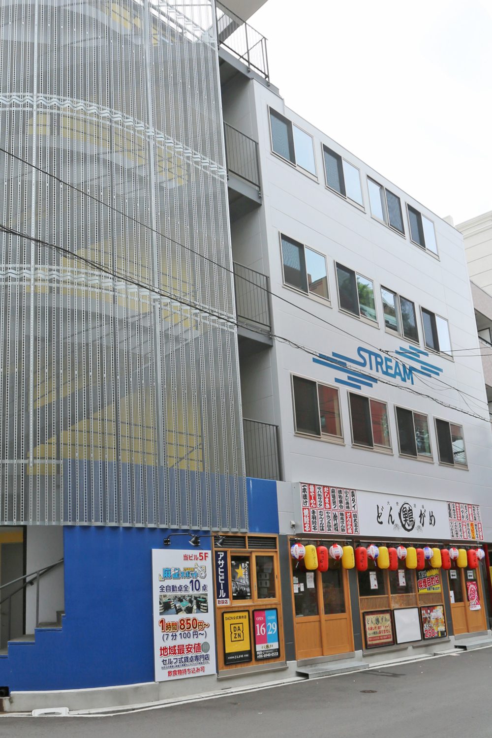 1階を鮮やかなブルーで塗装したパーソナルジムのビル外観